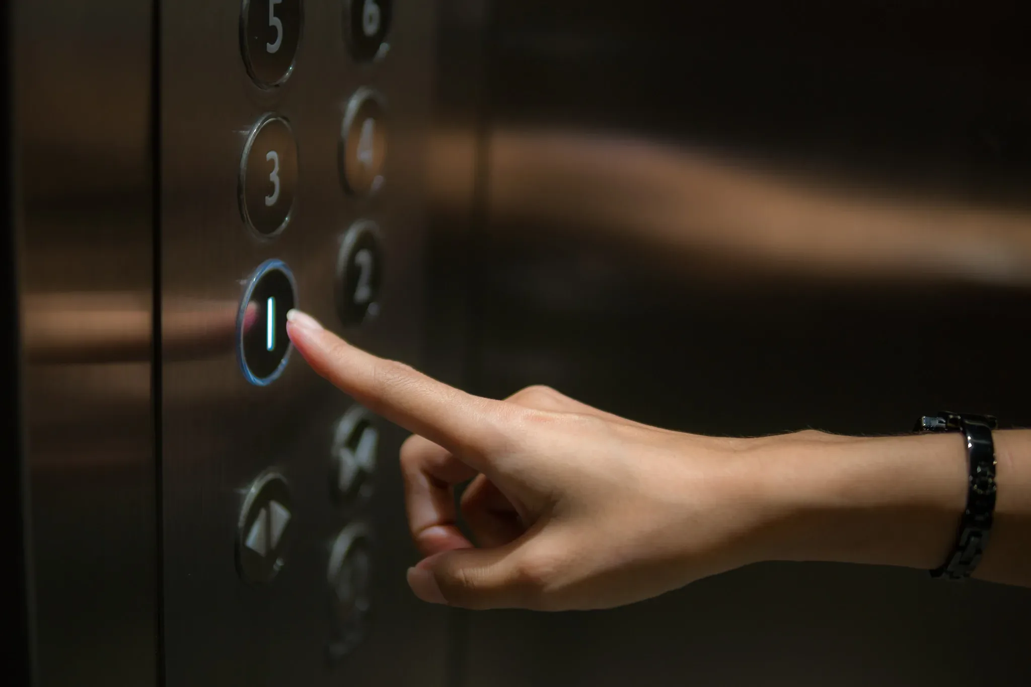 The,Finger,Is,The,Push,Button,Of,The,Elevator. A person pressing the button on an elevator.