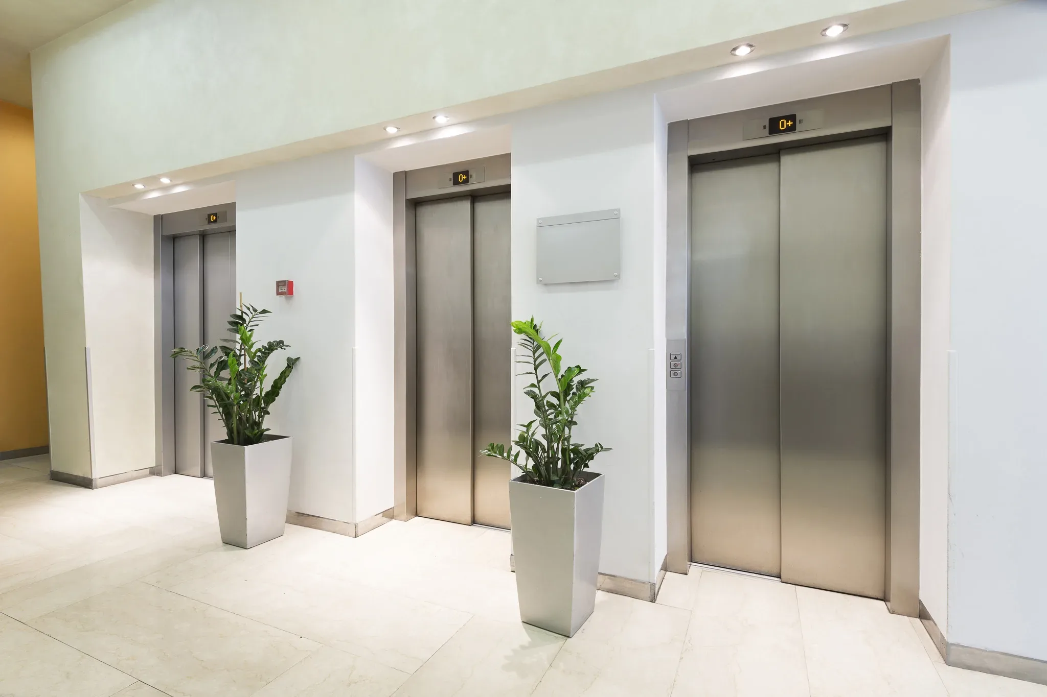 Three,Elevators,In,Hotel,Lobby A group of elevators in an office building.